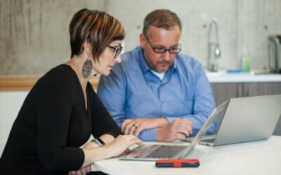 two people looking at their computers discussing something of importance