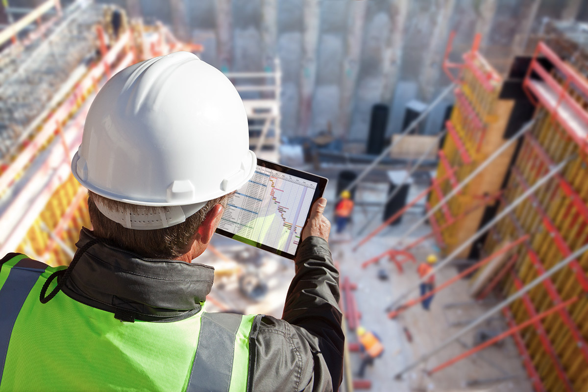 Construction Worker Checking Schedule Using Tablet Device